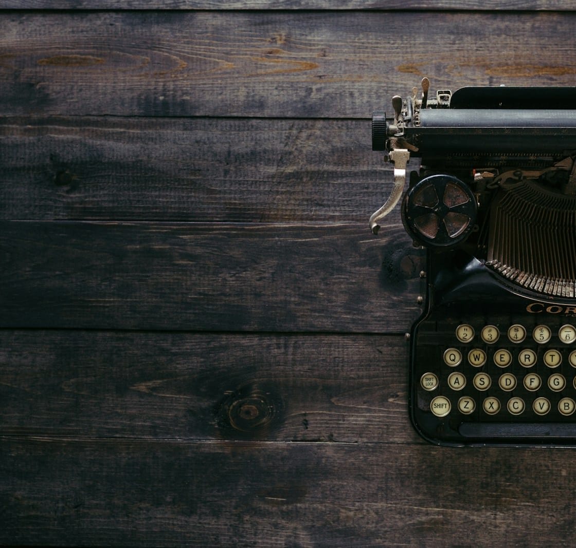black Corona typewriter on brown wood planks