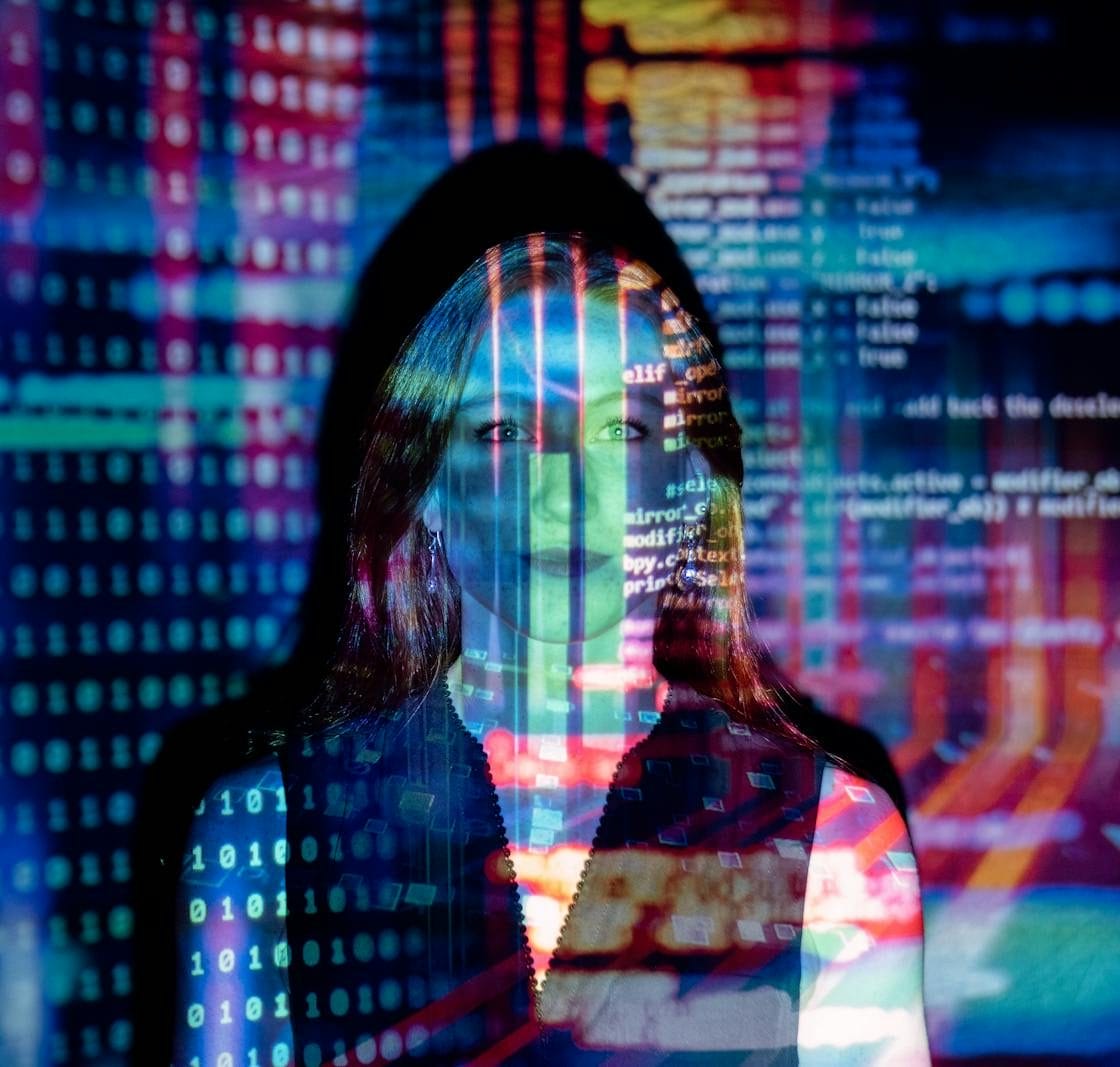 A woman with digital code projections on her face, representing technology and future concepts.